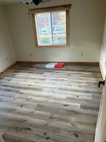a view of a room with wooden floor and window