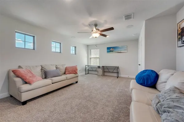 a living room with furniture and a ceiling fan