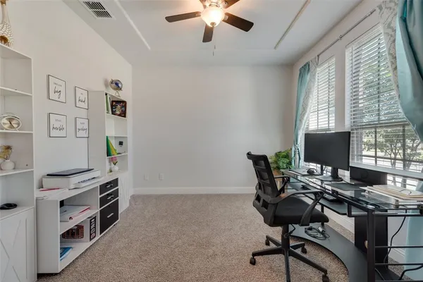 a view of a workspace with furniture and a window
