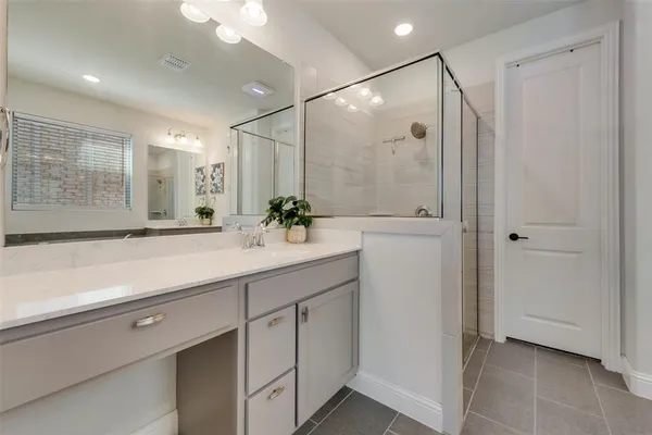 a bathroom with a shower sink and mirror