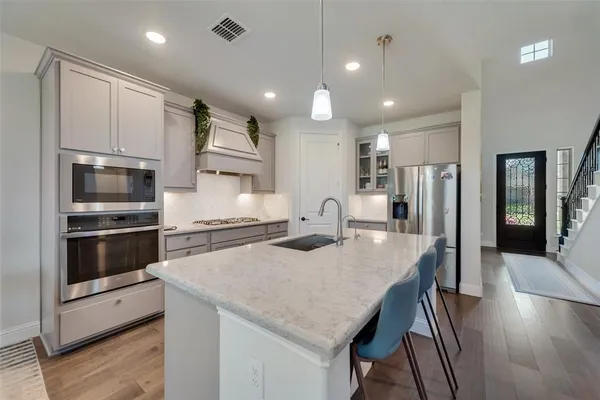 a kitchen with stainless steel appliances granite countertop a sink refrigerator and cabinets
