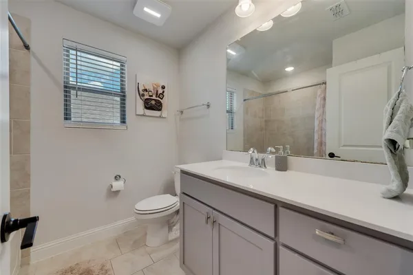a bathroom with a granite countertop sink a toilet and a mirror