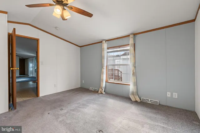 an empty room with chandelier fan