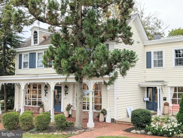 a front view of a house with a yard and potted plants