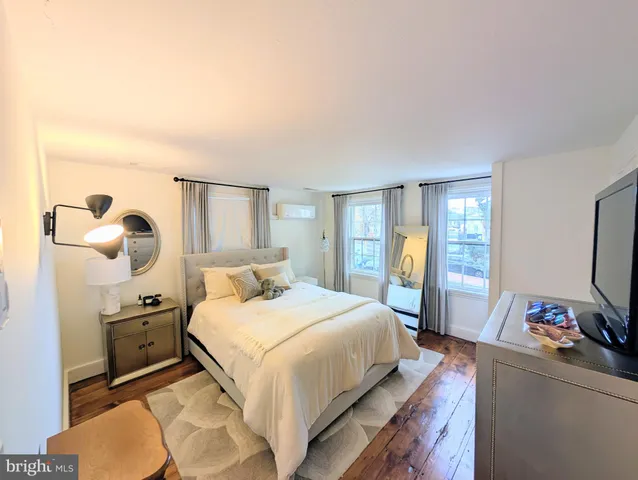 a view of an empty room with wooden floor and windows