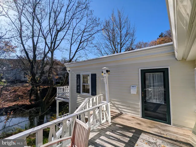 a view of a house with wooden deck next to a yard