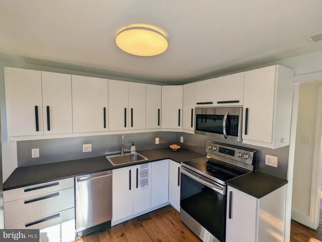 a kitchen with stainless steel appliances granite countertop a sink and a stove