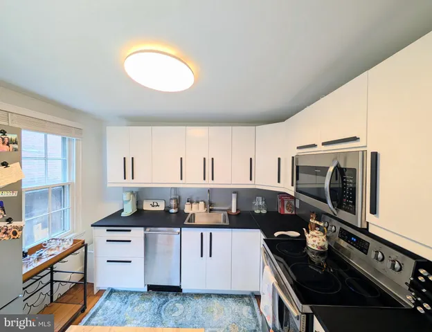 a kitchen with a stove a sink and a microwave