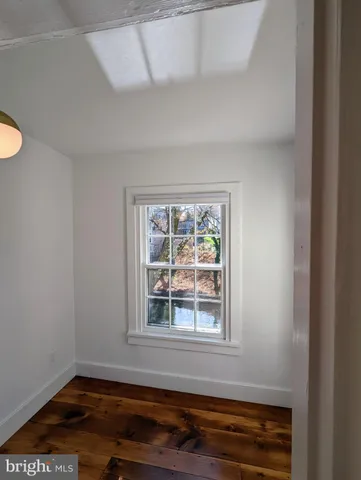 a bedroom with a bed and a flat tv screen on dresser