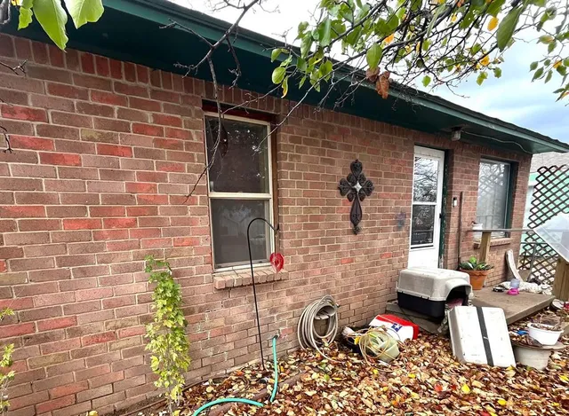 a brick building with a bench and a potted plant