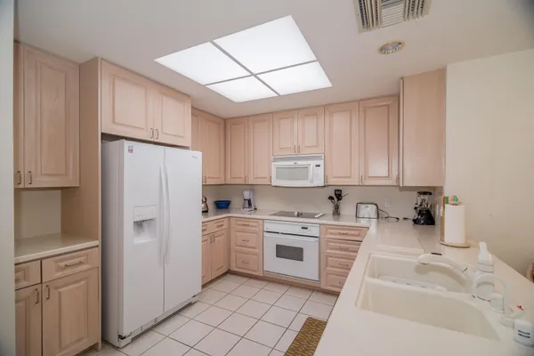 a kitchen with white cabinets and white appliances