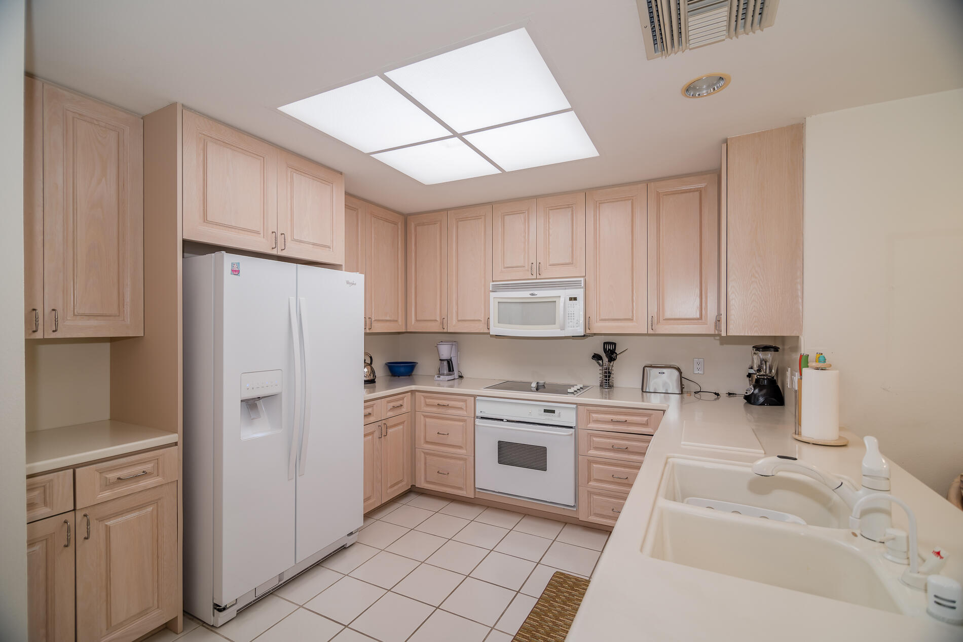 12 Columbia Drive Rancho Mirage, CA 92270 - Photo 12 of 25 a kitchen with white cabinets and white appliances