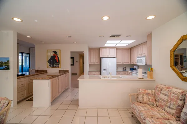 a large white kitchen with stainless steel appliances granite countertop a sink and cabinets