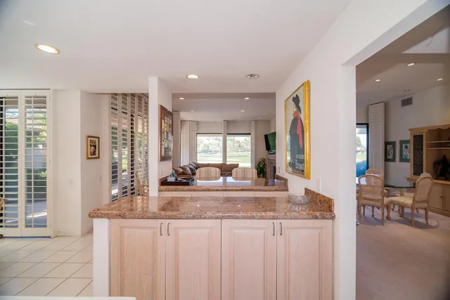 a view of kitchen with granite countertop cabinets and living room