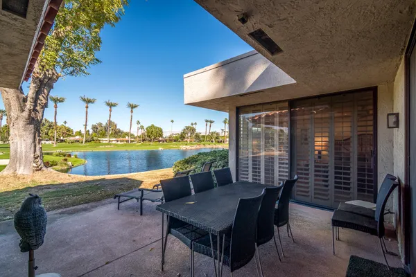 a view of a patio with a table chairs and a backyard