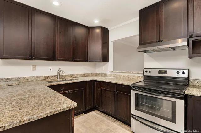 a kitchen with a sink stove top oven and cabinets