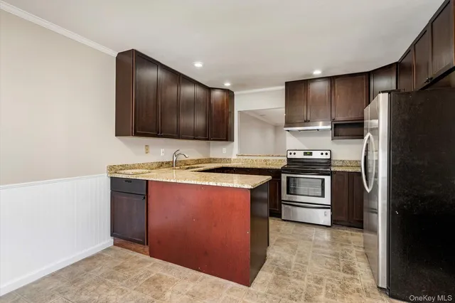 a kitchen with stainless steel appliances granite countertop a refrigerator and a stove top oven