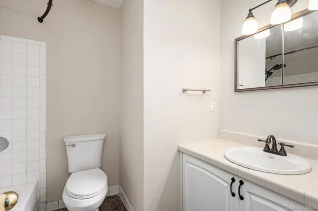 a bathroom with a toilet a sink and mirror