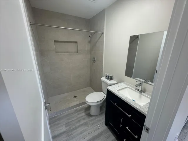 a bathroom with a granite countertop sink toilet and shower