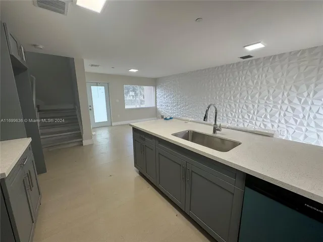 a kitchen with sink and refrigerator