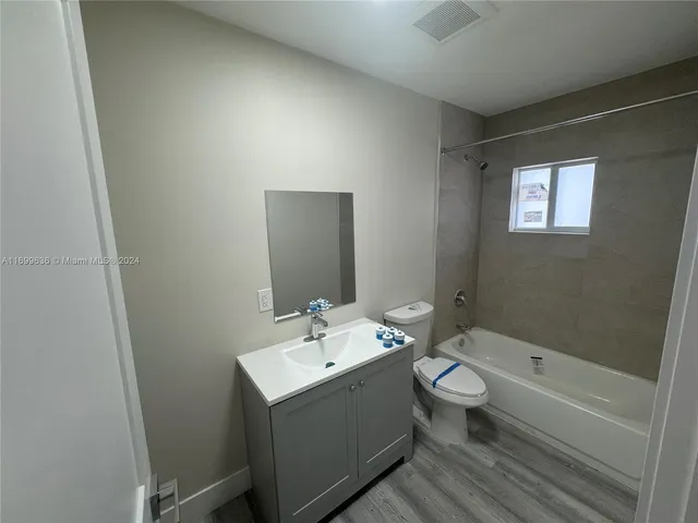 a bathroom with a double vanity sink toilet mirror and bathtub