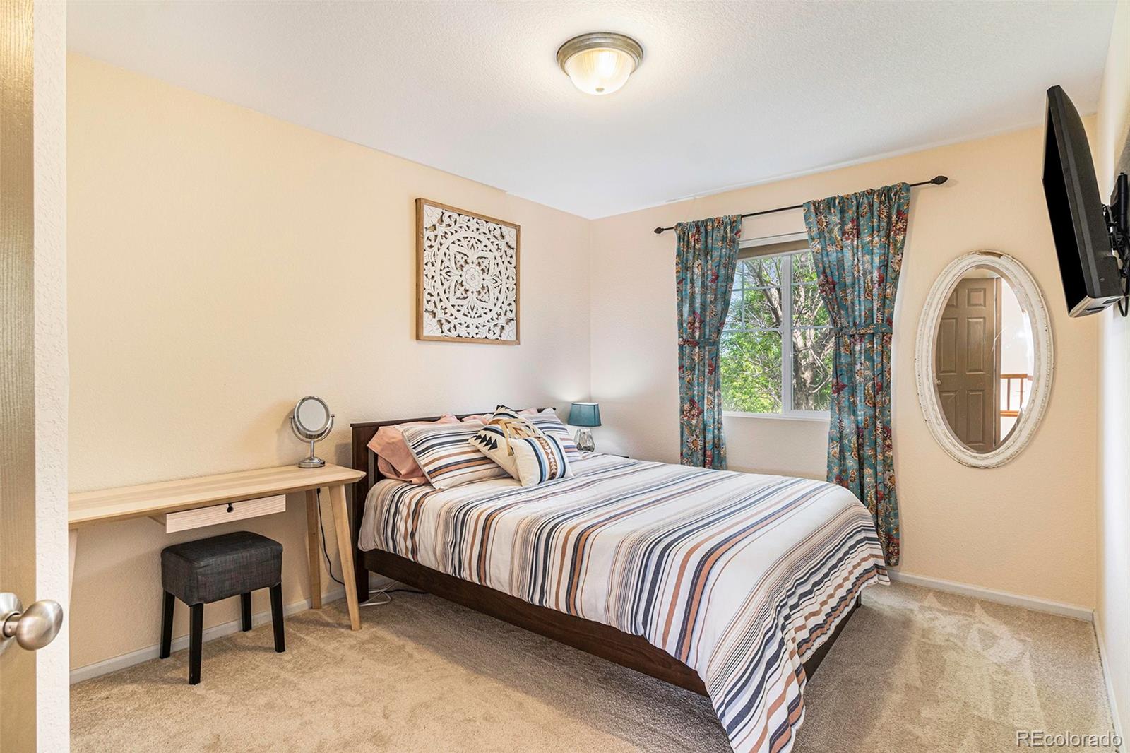 7395 Hickory Circle Frederick, CO 80504 - Photo 13 of 23 a bedroom with a bed a mirror and a desk