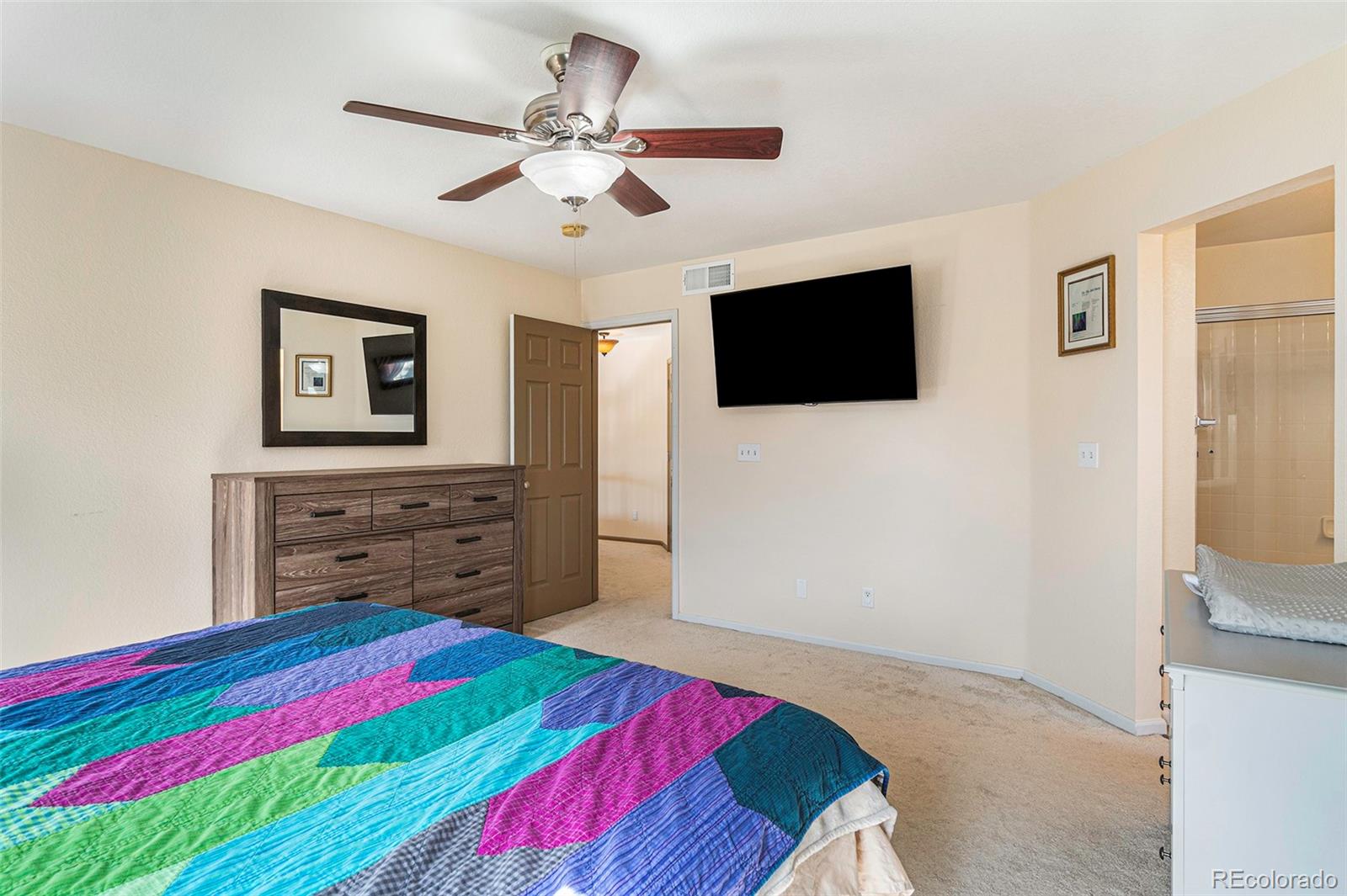 7395 Hickory Circle Frederick, CO 80504 - Photo 20 of 23 a bedroom with a bed and a flat screen tv
