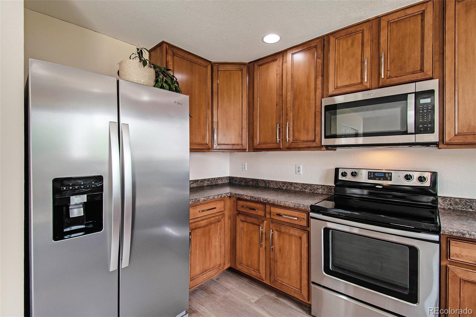 7395 Hickory Circle Frederick, CO 80504 - Photo 8 of 23 a kitchen with granite countertop stainless steel appliances and wooden cabinets