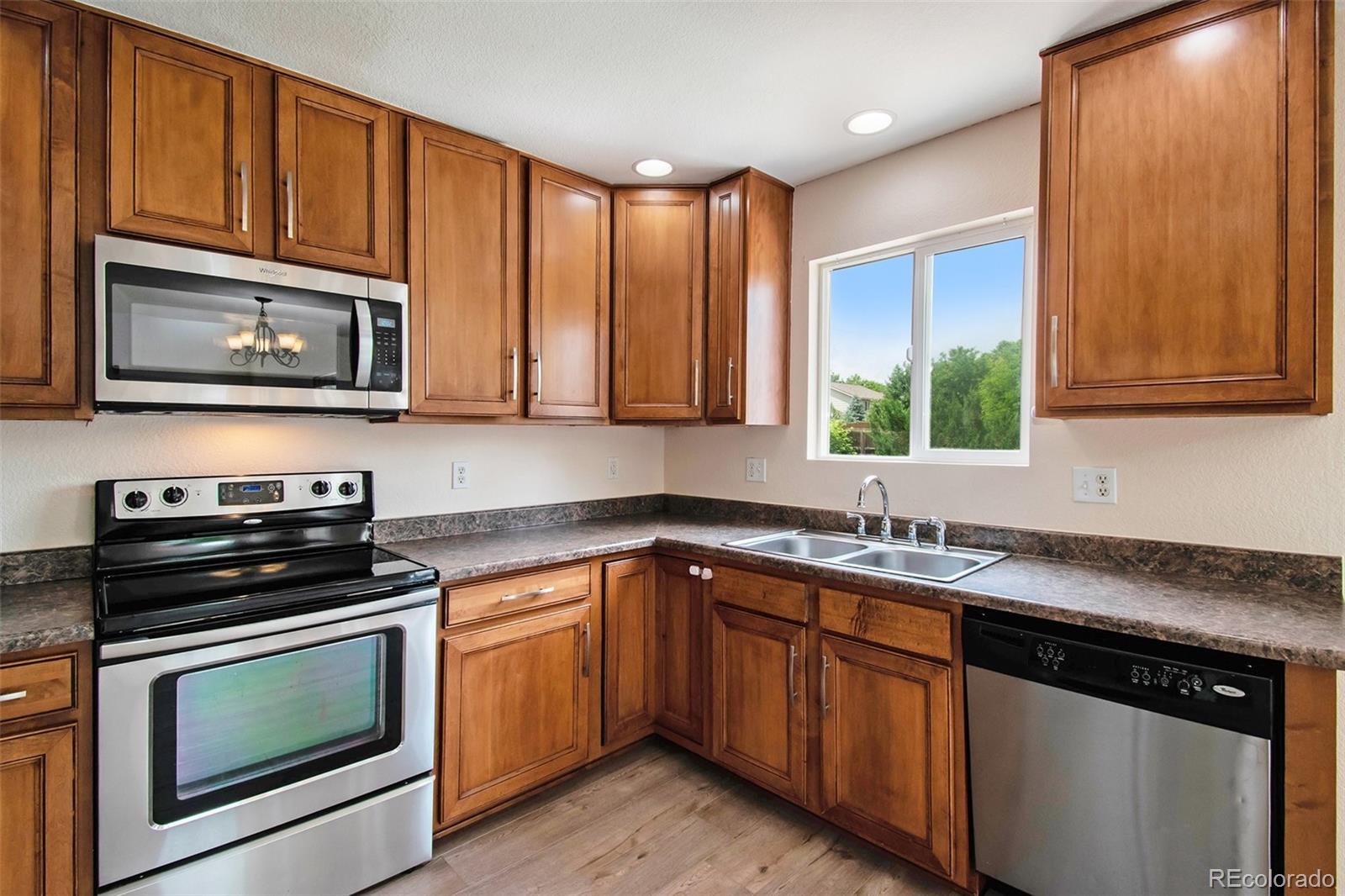 7395 Hickory Circle Frederick, CO 80504 - Photo 9 of 23 a kitchen with granite countertop cabinets stainless steel appliances and a window
