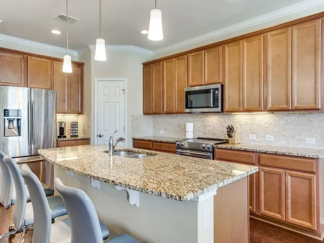a kitchen with granite countertop wooden cabinets and a granite counter top