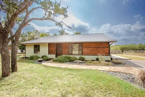 a view of a house with backyard and sitting area
