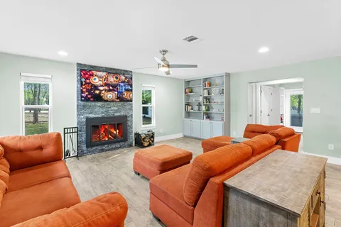 a living room with furniture a flat screen tv and a fireplace
