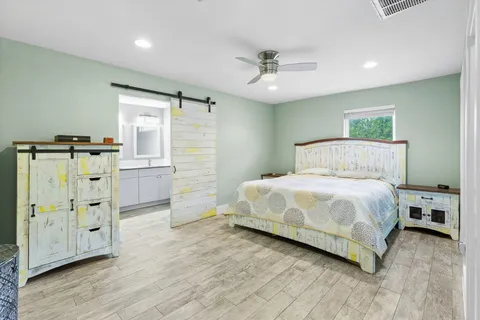 a bedroom with a bed and wooden floor