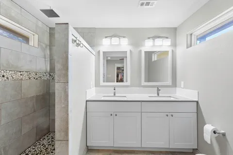 a bathroom with a double vanity sink and mirror