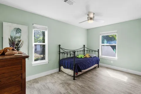 a bedroom with a bed and wooden floor