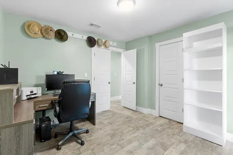 a view of a workspace with furniture and a window