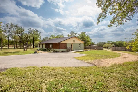 a view of house with yard and entertaining space
