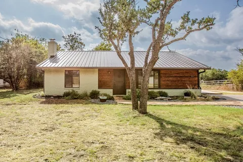 a front view of a house with a yard and seating space