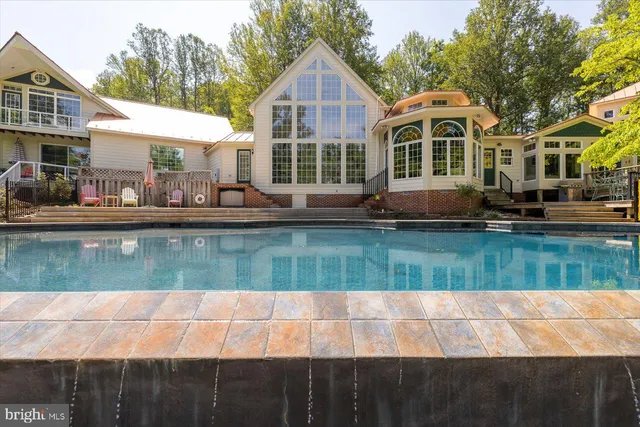 a view of a house with swimming pool and sitting area