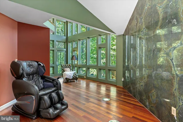 a kitchen with stainless steel appliances granite countertop a refrigerator a sink dishwasher a stove and a dining table with wooden floor