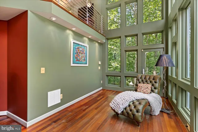 a work room with furniture a flat screen tv and a floor to ceiling window