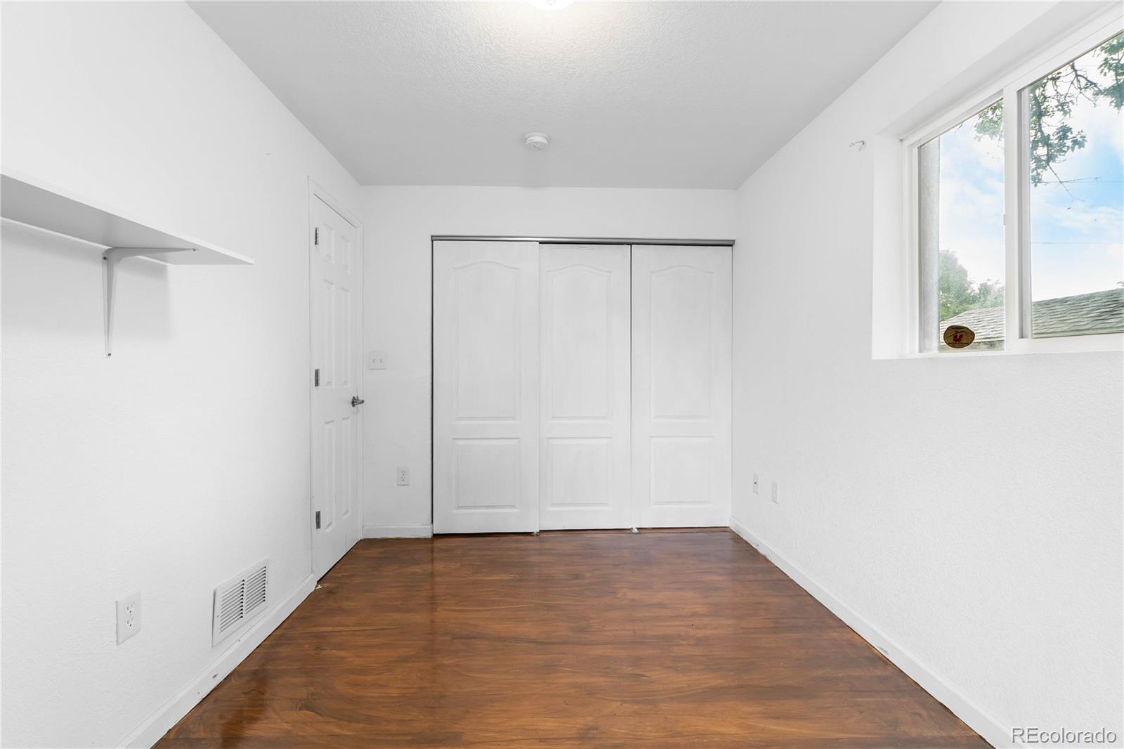 7010 West 44th Avenue Wheat Ridge, CO 80033 - Photo 25 of 31 a view of a room with wooden floor and a window