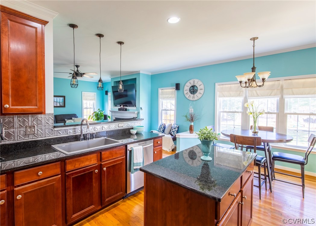 5925 Springmount Road Chesterfield, VA 23832 - Photo 14 of 35 a kitchen with kitchen island granite countertop a stove a sink a dining table and chairs with wooden floor