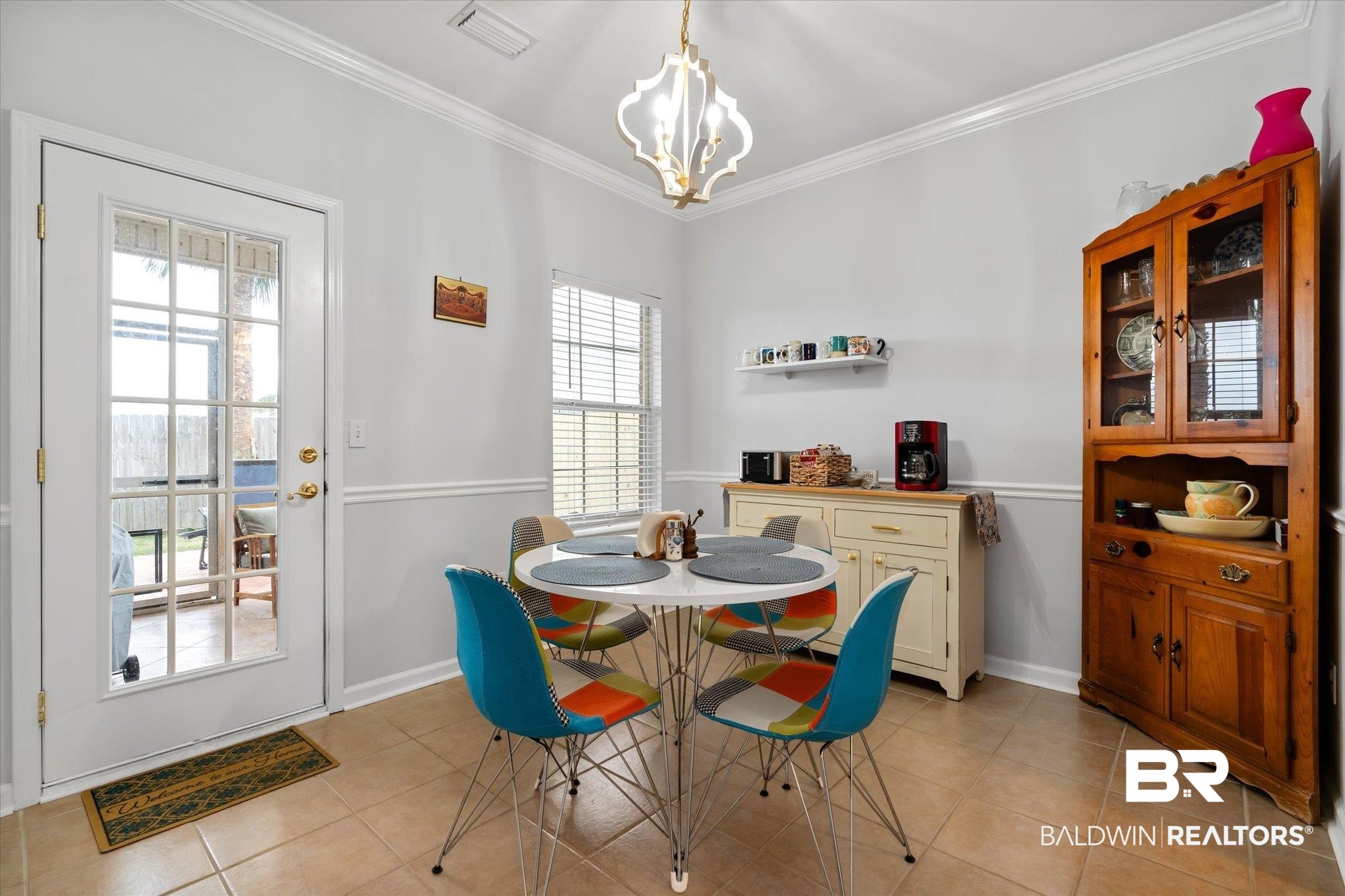 3876 Emerille Drive Foley, AL 36535 - Photo 8 of 31 Tiled dining area with crown molding and an inviting chandelier