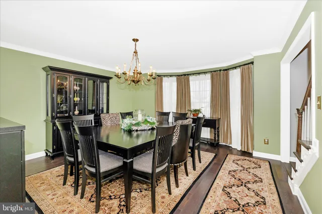 a dining room with furniture a rug a flat screen tv and a floor to ceiling window