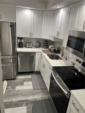 a kitchen with a sink appliances and cabinets
