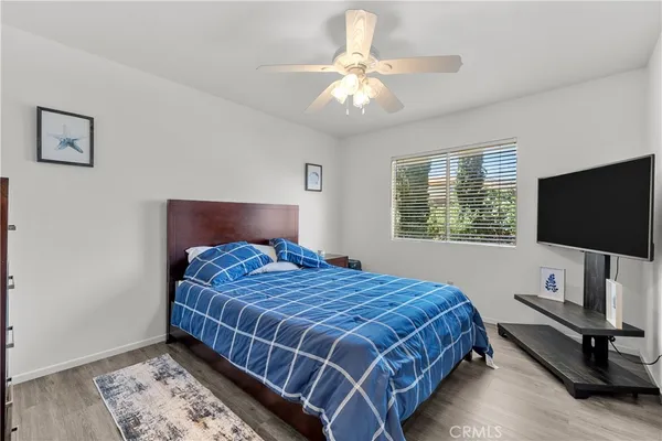 a bedroom with a bed a flat screen tv and a window