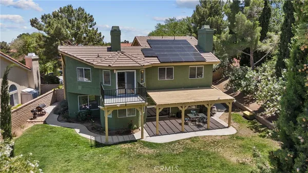 aerial view of a house with a yard balcony and furniture