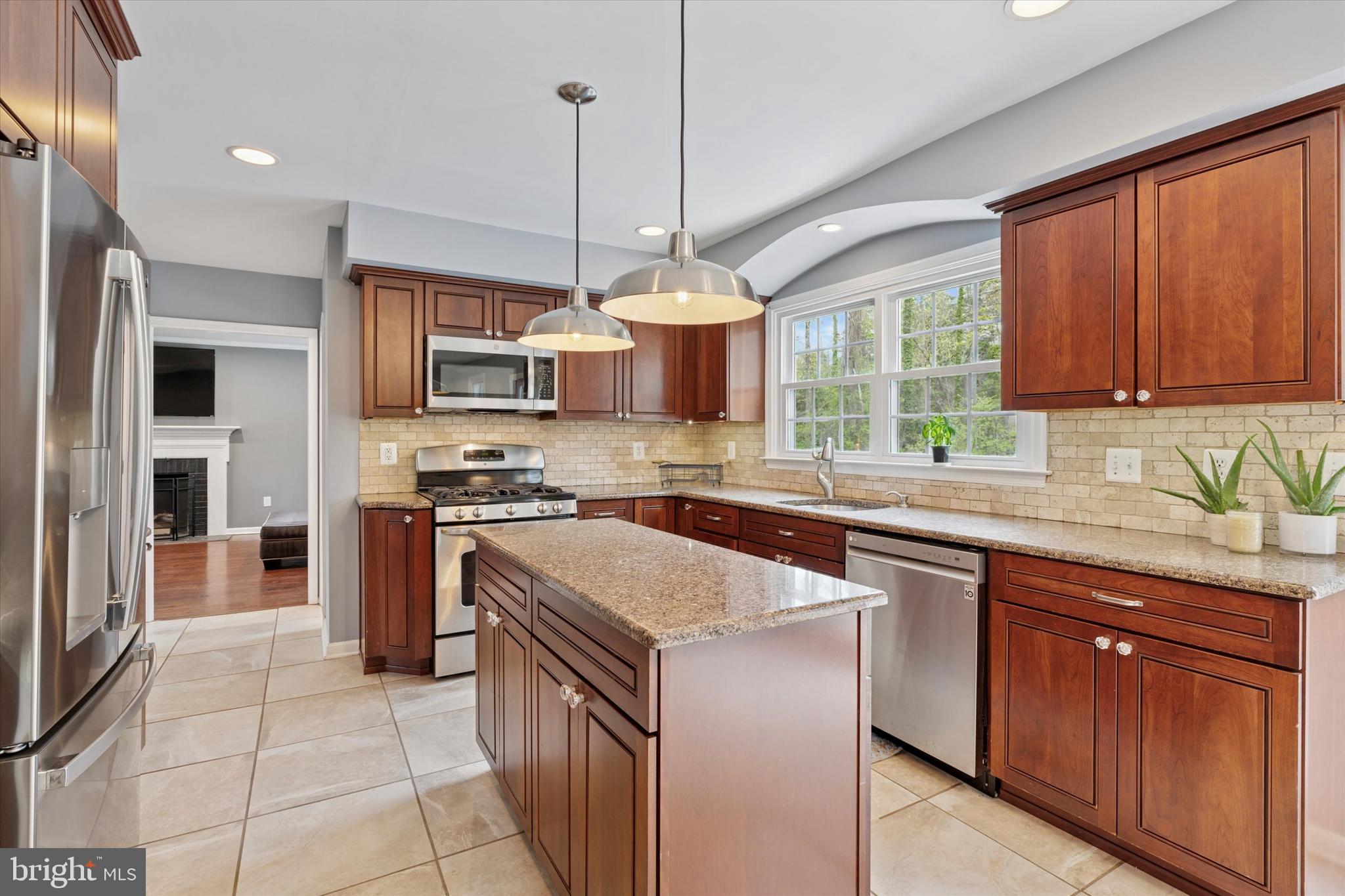78 Peddrick Road Wayne, PA 19087 - Photo 12 of 47 a kitchen with stainless steel appliances granite countertop a stove top oven a sink dishwasher a dining table and chairs with wooden floor
