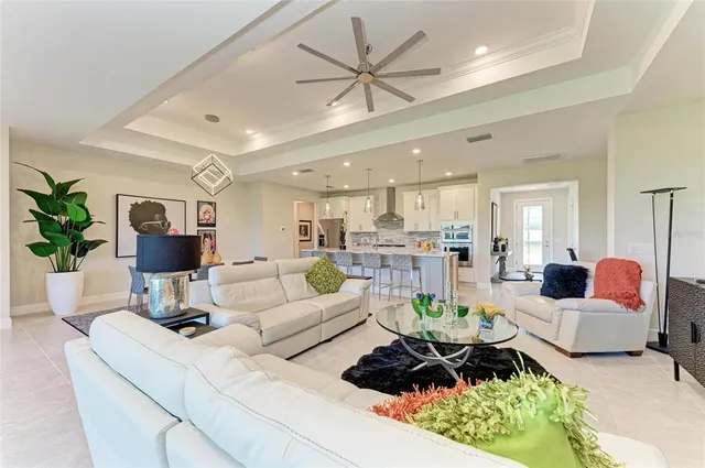 a living room with furniture a table and kitchen view